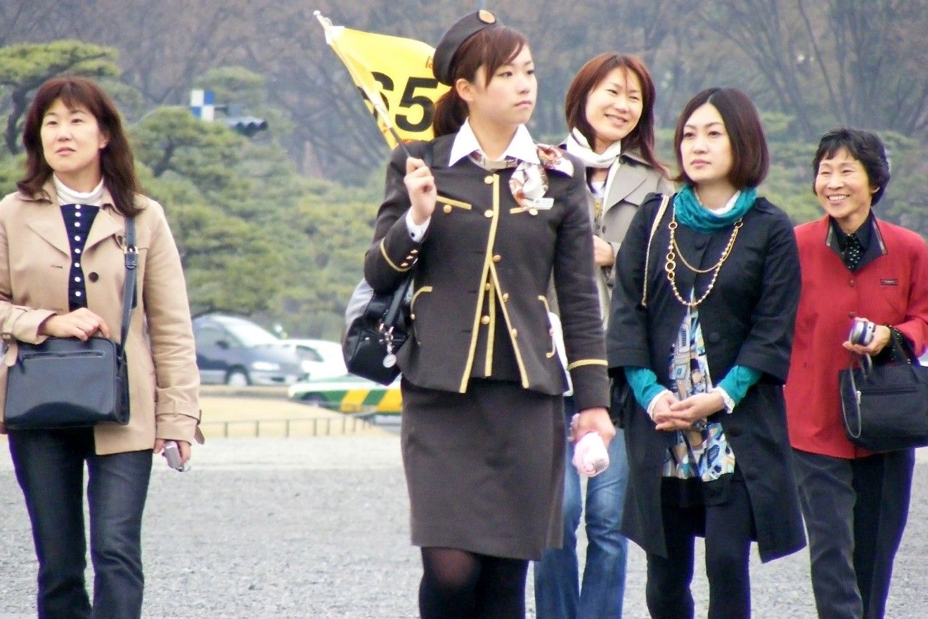 A tour guide leading tourists on a hill side.