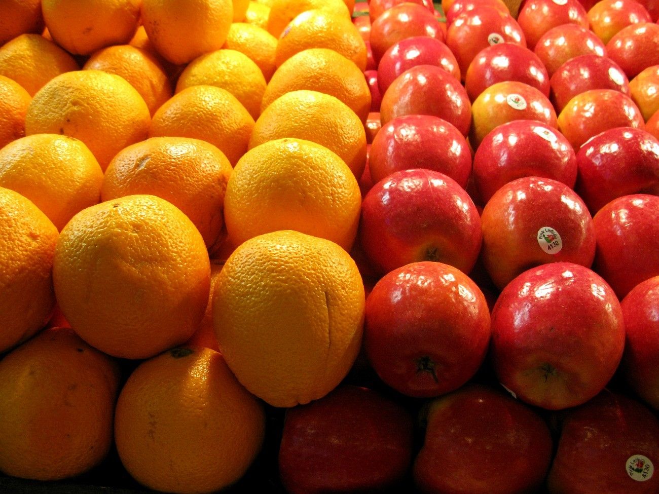 Oranges and apples in a market shelf.