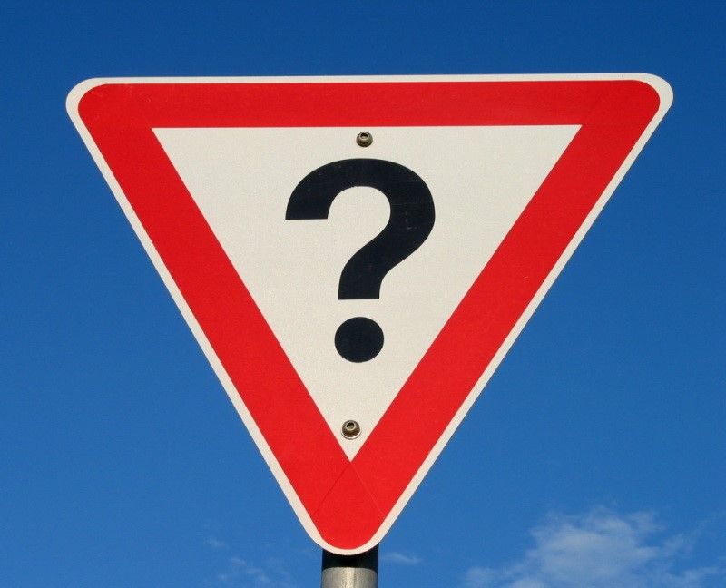 A road sign with a giant question mark on it.