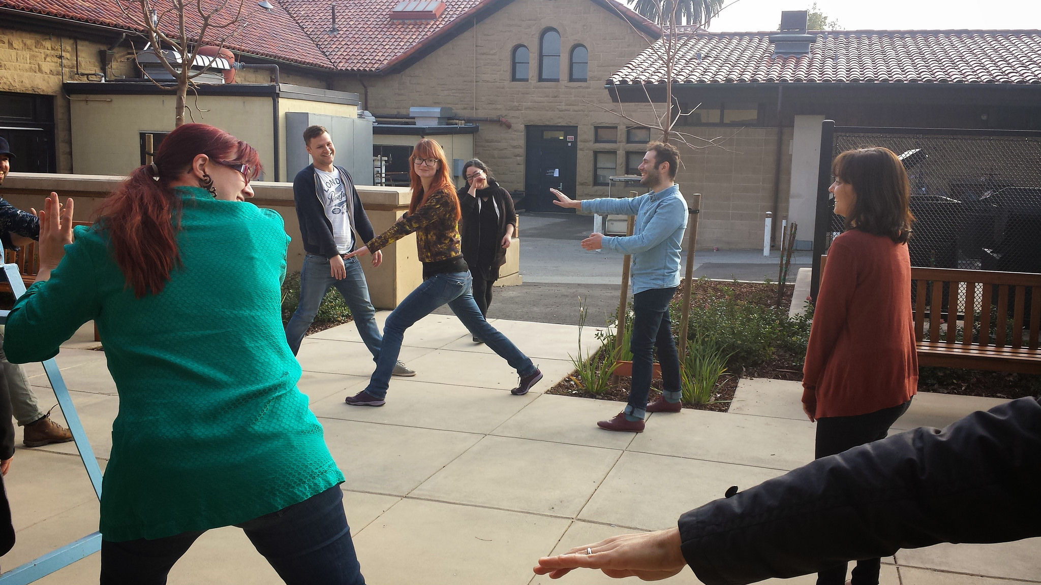 Photo of a group of people outside playing a game involving their whole bodies as an ice breaker.